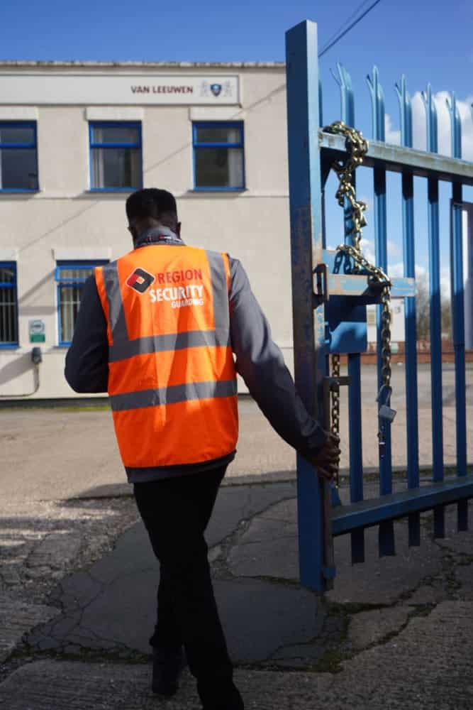 Factory security guard monitoring industrial site entrance