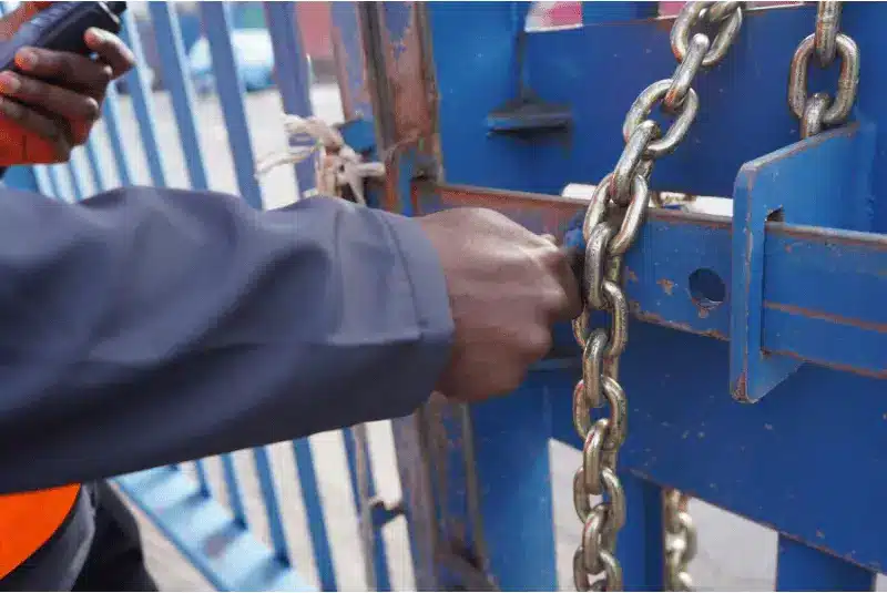 A security guard locking up a gate
