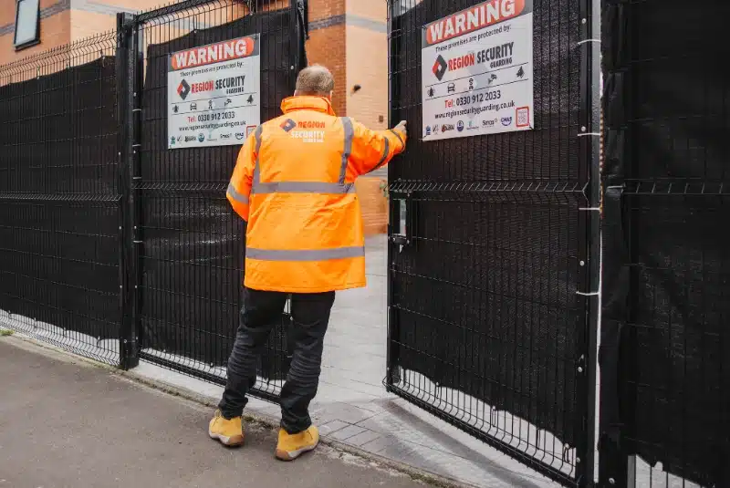 A Castle Donington security guard checking a entrance gate is secured