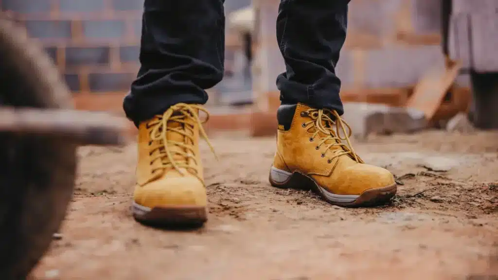 A close-up of a rail construction security guard's boots, stood in an active site.