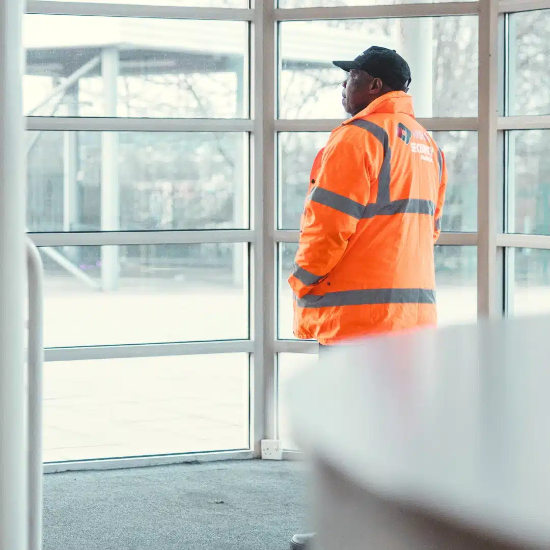 Manned guard in high-vis jacket securing interior entrance of a business in Leicester