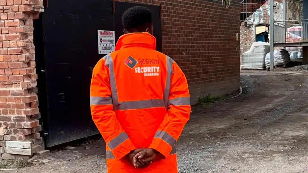A security guard monitors a building site, representing security services Warwick
