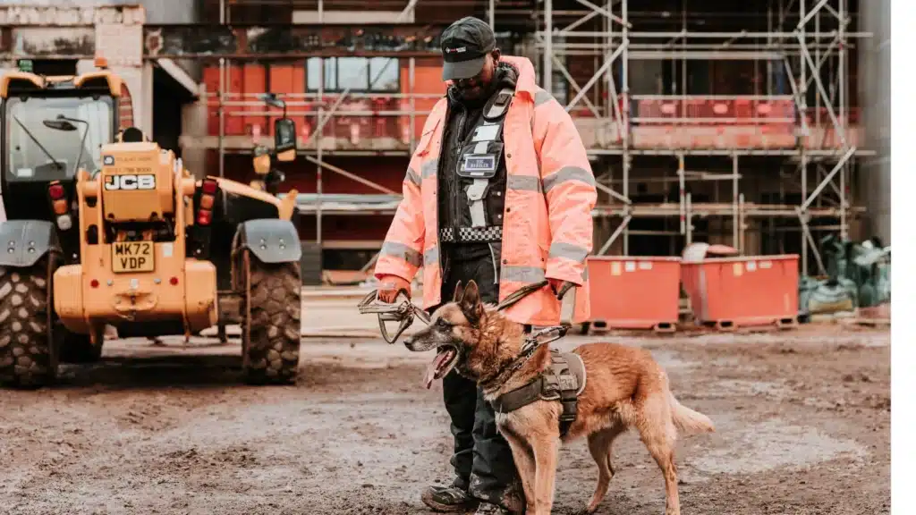 A security guard with a K9 dog stands on a construction site, ready for construction site security patrols Leamington Spa