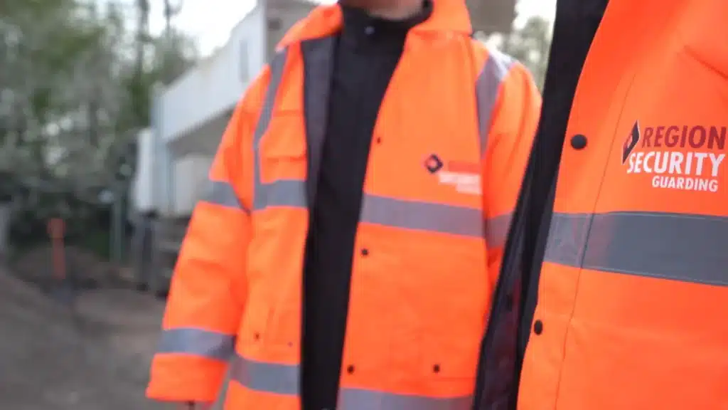 Two security guards in high-visibility jackets with Region Security Guarding logo, representing a security provider Tipton