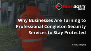 A Congleton security services guard from Region Security Guarding is seen from the back, wearing a hi-vis jacket as he stands near a gate