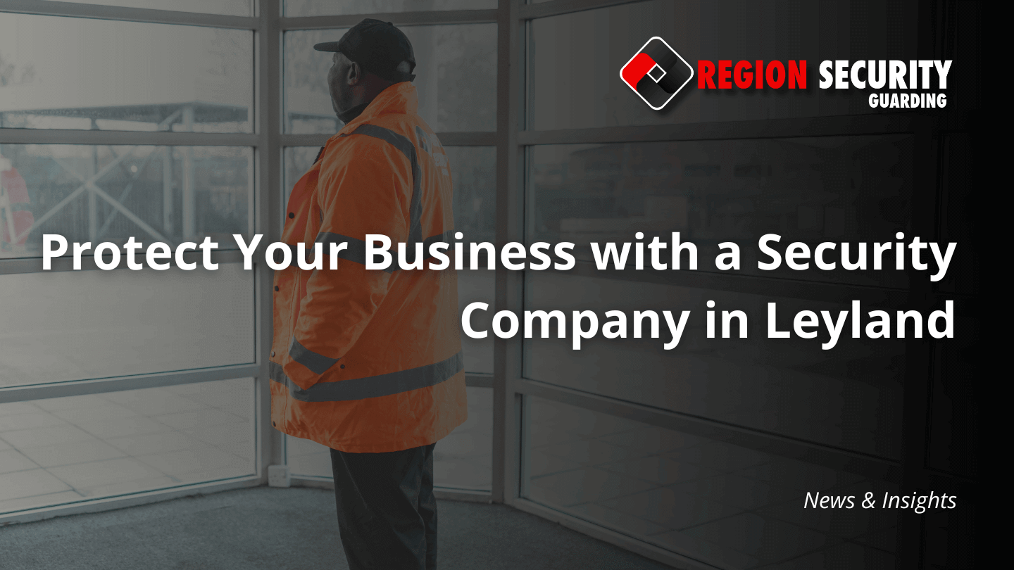 An SIA-licensed guard from a leading security company in Leyland is standing inside the glass doors of a commercial building.