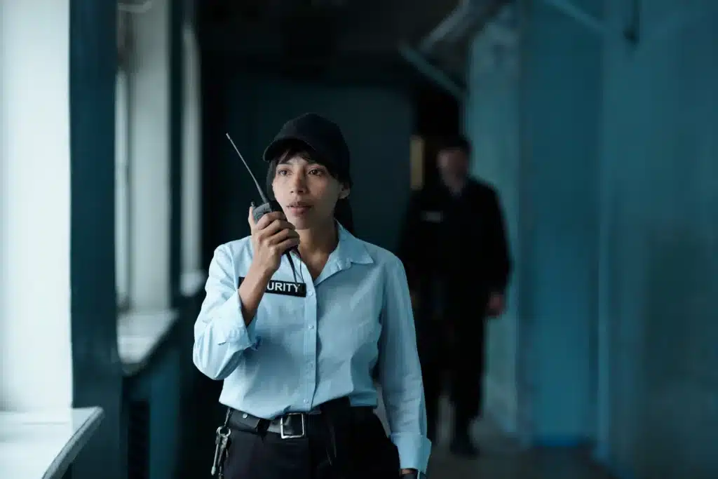 Female security guard speaking on a walkie-talkie during professional security operations