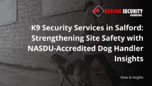 A security professional walks a trained dog along a sidewalk next to a brick building, highlighting K9 security services in Salford.