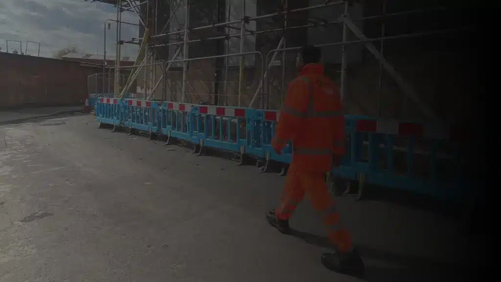 Warehouse security guard patrolling industrial site in Birmingham wearing high visibility uniform